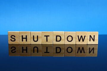 shutdown word made of wooden letters on a mirror surface