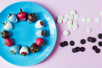 Strawberries in chocolate on a blue plate and pink background, dessert for Valentine's Day, romance, food gift. Homemade red strawberries in chocolate. Postcard with a romantic dessert with free space