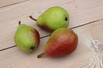 Multi-colored ripe pears on background of boards.