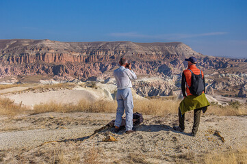  A man with a camera takes pictures of a beautiful cave complex in Cappadocia. Turkey