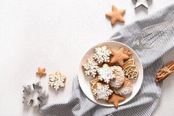 Christmas gingerbread glazed cookies in plate on white background. View from above. Flat lay.