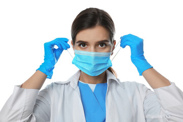 Fototapeta na wymiar Doctor in medical gloves putting on protective mask against white background