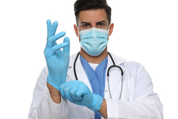 Doctor in protective mask putting on medical gloves against white background