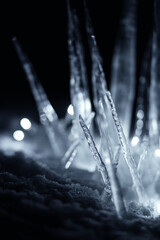 Obraz na płótnie Canvas illuminated icicles in snow at dark night