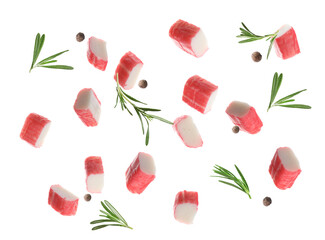 Cut fresh crab sticks, rosemary and allspice falling on white background