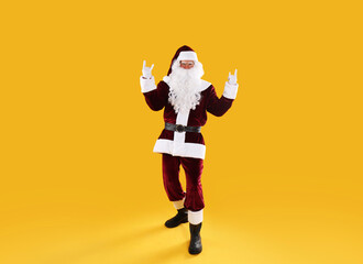 Fototapeta na wymiar Full length portrait of Santa Claus on yellow background