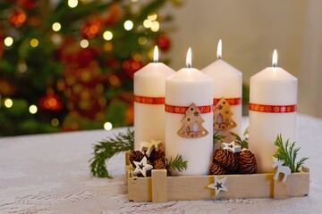Christmas candles on the table, blurred lights background