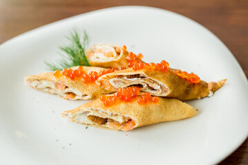 pancakes rolls with salmon and red caviar