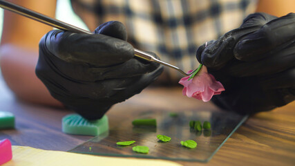 Small business concept. Professional artisan works with polymer clay at workshop.