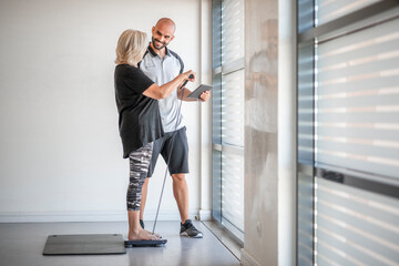 Personal trainer evaluating health of elderly fit woman