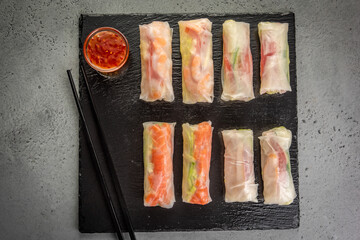 vietnamese spring rolls with Salmon and sauce on gray background