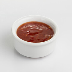 Sweet chili sauce in ceramic bowl isolated on a white background.Top view