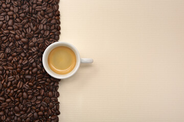 Strip of coffee beans and a cup of espresso on a paper surface