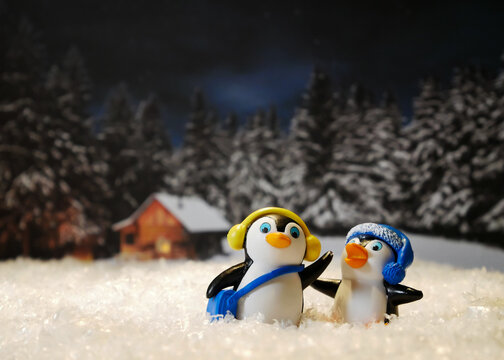 Pinguine als Miniaturfiguren mit Musik im Schnee mit Wald