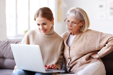 Mother and daughter using laptop together.