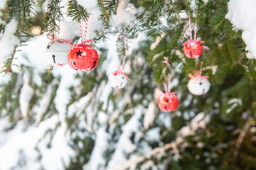 Bell baubles on Christmas tree outdoors, snowy winter, Xmas time