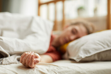 Close-up of young woman lying on bed and sleeping at home