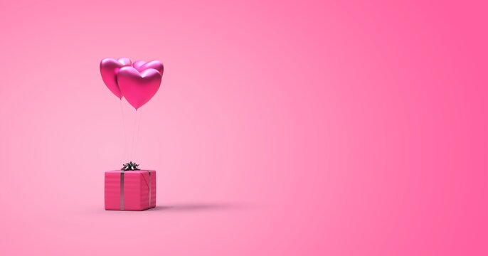 Cadeau accroch&eacute; &agrave; des ballons en forme de coeur pour symboliser l'amour
