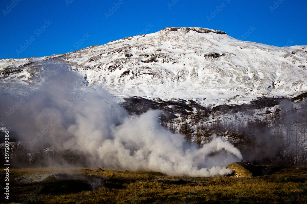 Wall mural steam and snow covered mountains