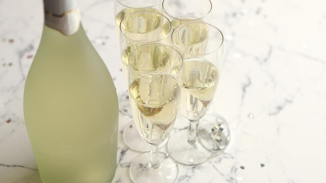 Champagne glasses and bottle placed on white marble background