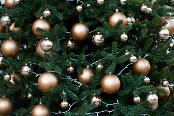 Obraz na płótnie Canvas Closeup view of green christmas tree decorated with golden balls and lights.