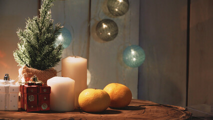 Small Christmas tree and candles on a wooden background