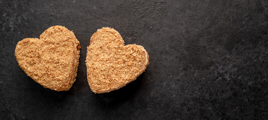 Two heart shaped cakes on a stone background with copy space for your text