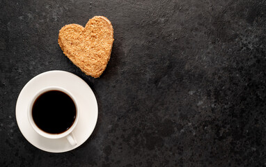 Festive breakfast for valentine's day. Coffee and heart shaped cake on a stone background with copy space for your text
