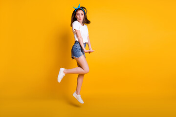 Fototapeta na wymiar Full length body size photo of young woman jumping flirty with pouted lips isolated on vibrant yellow color background