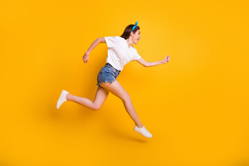 Full length body size side profile photo of girl running fast jumping high yelling isolated on vibrant yellow color background