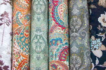 Fabricate silk and cloth on the shop shelf, multicolor pattern, rolled silk in the market