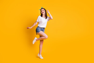 Fototapeta na wymiar Full length body size view of slim pretty cheerful brown-haired girl jumping having fun dancing isolated over bright yellow color background