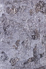 Shiny heavily wrinkled metal silver gray foil vertical texture background for design