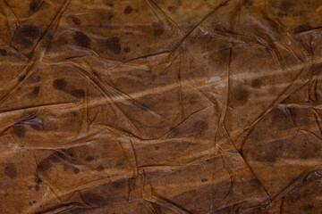 Textured dirty wrinkled brown old paper background. Horizontal background for design, closeup