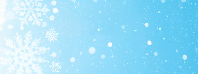 Fototapeta na wymiar snowflakes isolated on blue sky illuminated by the sun - winter background panorama banner long