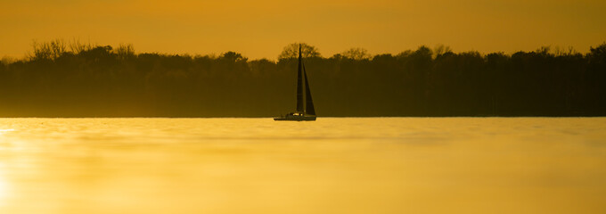Sailboat in beautiful sunset light panorama