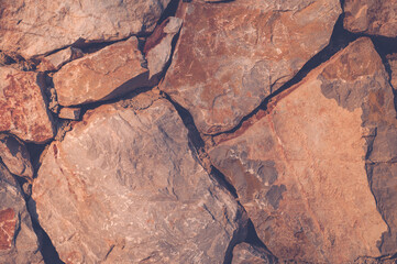 Modern wall of large unprocessed pieces of rock, stones. Background stone wall.