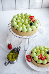 Round shortcrust cake with green pistachio cream and strawberry jam. Pistachio tart with cream cheese, top view