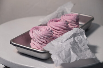 Pink strawberry homemade zephyr or marshmallow in a rectangular oleum plate. side view, close-up, selective focus