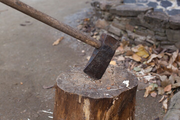 Detail on an ax as it cuts logs of wood.
