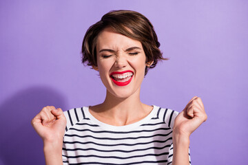 Portrait of funky sweet short brunette hairdo girl yelling hands fists closed eyes wear stripped pullover isolated on violet background