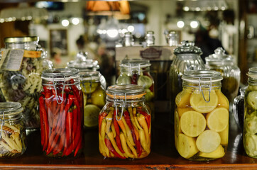 Fototapeta na wymiar Background of food stocks in glass jars. Plenty of bright jars with pickled vegetables and fruits