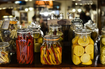 Background of food stocks in glass jars. Plenty of bright jars with pickled vegetables and fruits