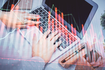 Double exposure of woman hands typing on computer and forex chart hologram drawing. Stock market analysis concept.