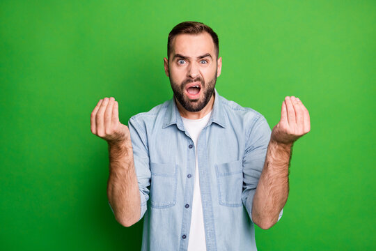 Portrait of angry man wear blue shirt want more money isolated on green color background