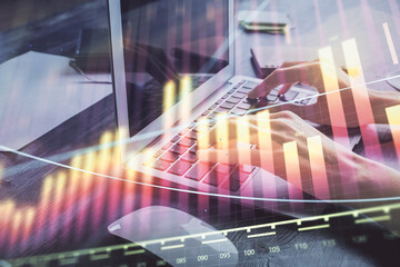 Double exposure of woman hands typing on computer and forex chart hologram drawing. Stock market...