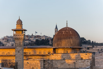 Fototapeta premium Siliver dome of Al-Aqsa Mosque under sunset in the evening, built on top of the Temple Mount, known as Haram esh-Sharif in Islam and al-Fakhariyya Minaret and wall of old city of Jerusalem, Israel.