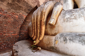 Close-up. Hand of Ancient Buddha statue at Wat Si Chum or Sri Chum. Temple in Sukhothai historical park. UNESCO world heritage. One popular tourist destination in Sukhothai, Thailand.
