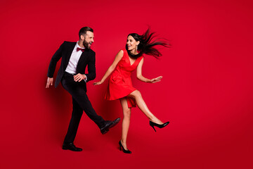 Full size profile photo of funky couple dance wear vivid dress black suit isolated on red color background