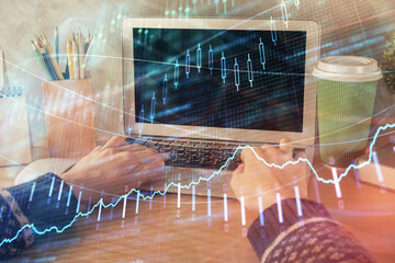 Double exposure of woman hands typing on computer and forex chart hologram drawing. Stock market invest concept.